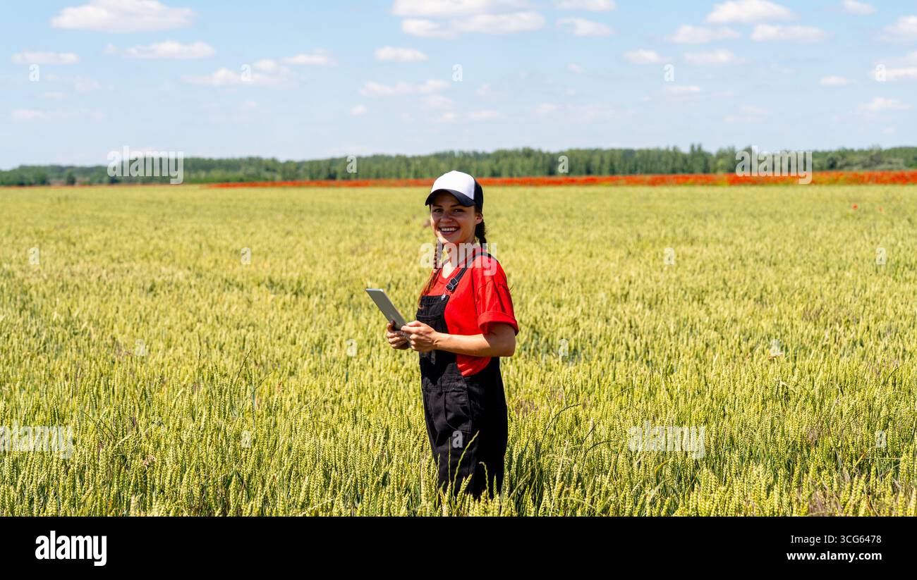 Nachhaltiges Landwirtschaftskonzept mit modernen Landwirtinnen, die Getreidekulturen in der Wachstumsphase mit einem digitalen Tablet kontrollieren Stockfoto
