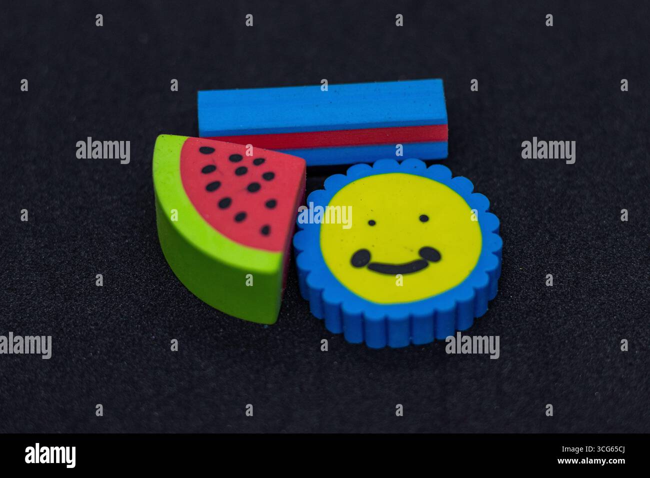 Eine Sammlung farbenfroher Radierer in lustigen und verspielten Formen auf schwarzem Hintergrund. Ideal für Schulbedarf, Schreibwaren für Kinder und c Stockfoto