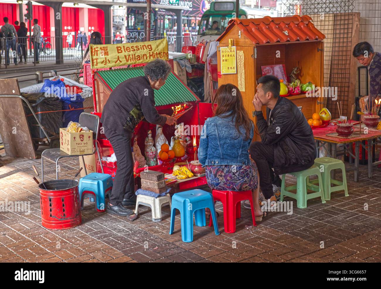 Die Schurken schlagen in der Canal Street, Hongkong - ein Ritual, bei dem Menschen kommen, um die Figuren des Unglücks und des Fehlverhaltens in ihrem Leben abzuwehren. Stockfoto
