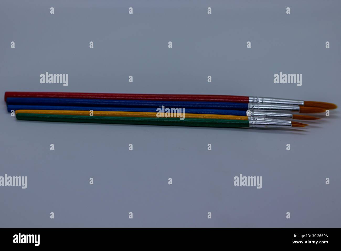 Buntes Holzpinselset mit Metallhülsen, angeordnet auf einem sauberen weißen Hintergrund. Ideal für Künstler, Studenten und Hobbyisten. Vielseitig b Stockfoto