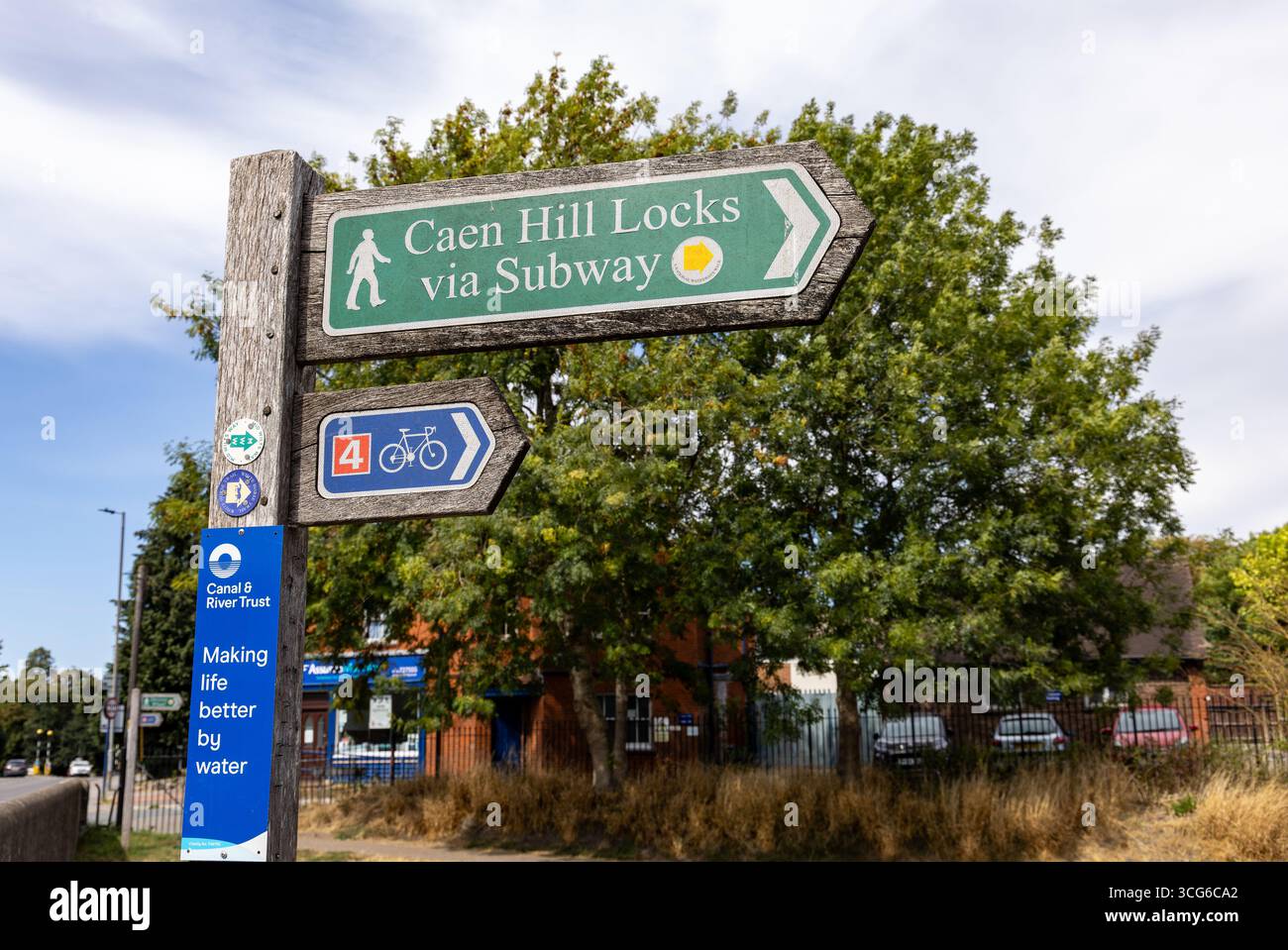 Richtungsschilder in der Nähe von Bäumen, die auf Caen Hill Locks, Kanalweg und Radweg bei sonnigem Wetter hinweisen Stockfoto