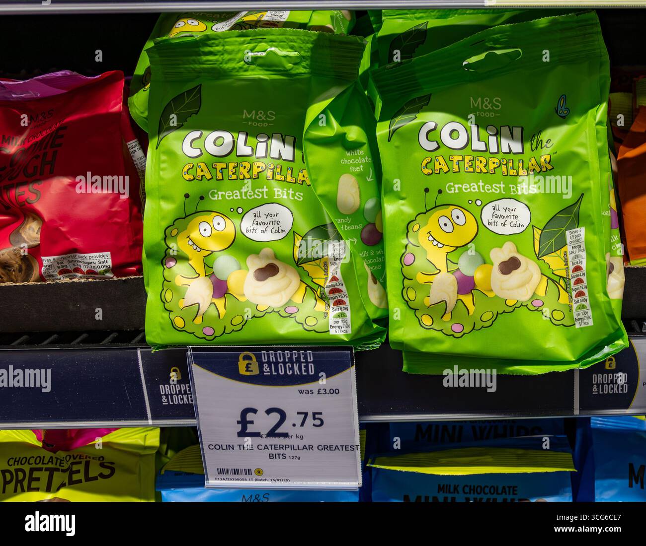 Marks & Spencer Colin die Caterpillar Sweet Bags in einem Supermarktregal mit Preisschild und farbenfroher Verpackung. Stockfoto