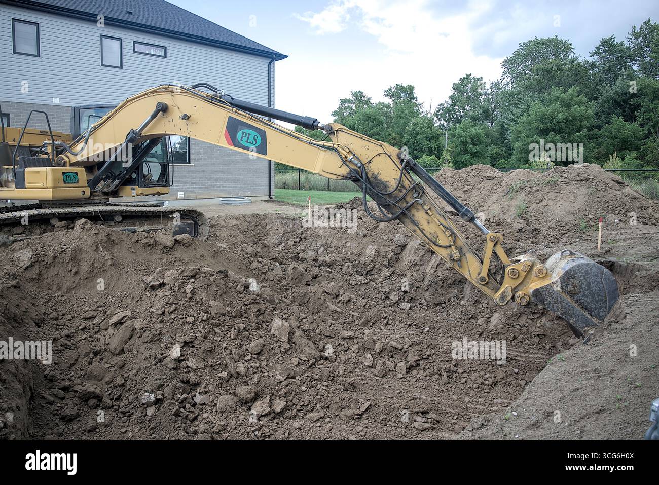 Bagger gräbt ein großes Loch für ein neues Gebäude. Stockfoto