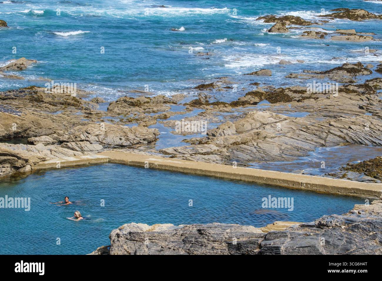 Cornwall, England, Großbritannien Frauen schwimmen in einem Meerwasserpool („Tinker Bunny's Bathing Pool“), nahe Trevone, am Conrwall Coast Path. Stockfoto