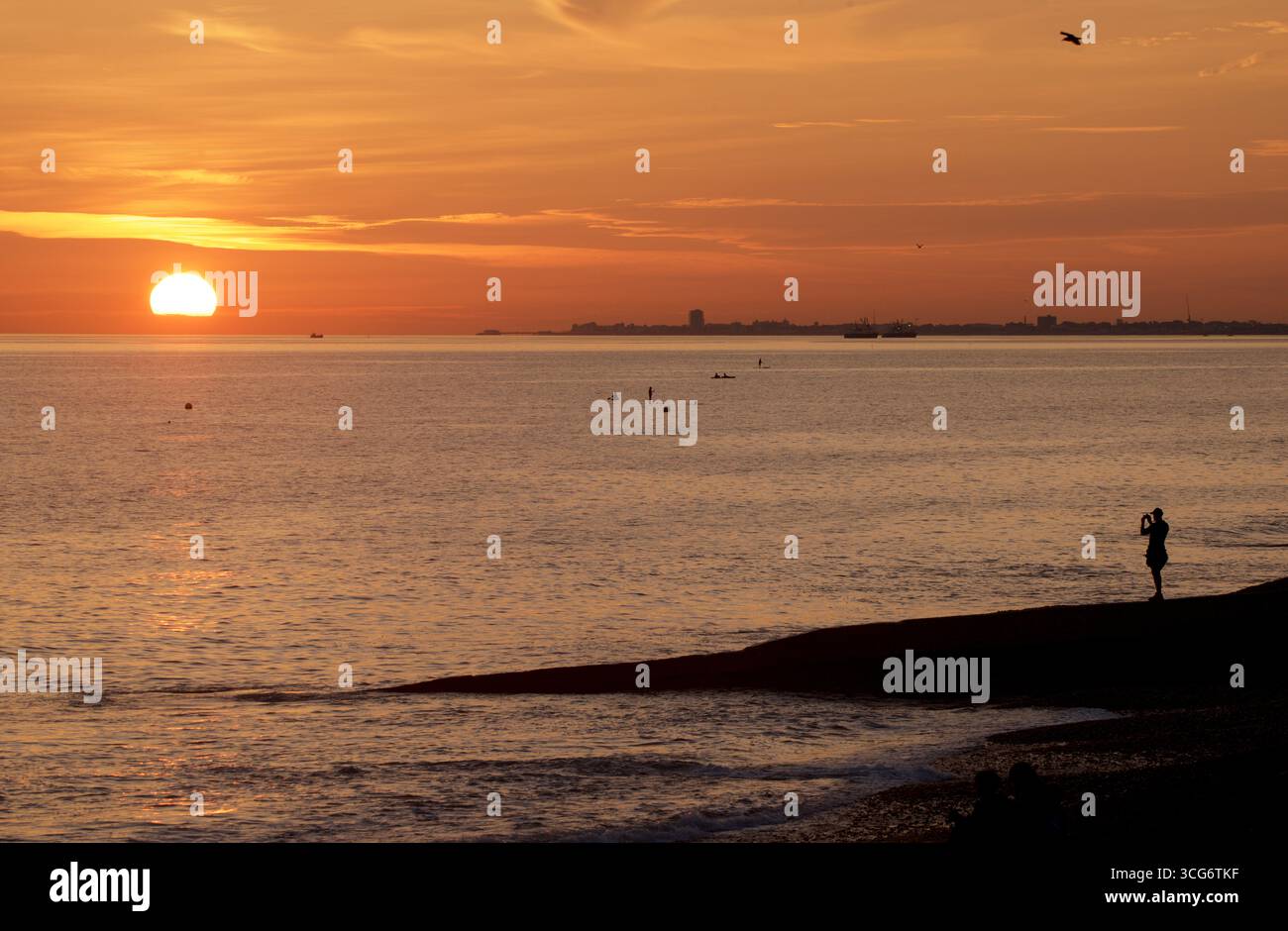 Person, die auf einem Groyne in Brighton in den Ärmelkanal führt, mit Blick nach Westen in Richtung Worthing. Brighton und Hove, Sussex, England, Großbritannien Stockfoto