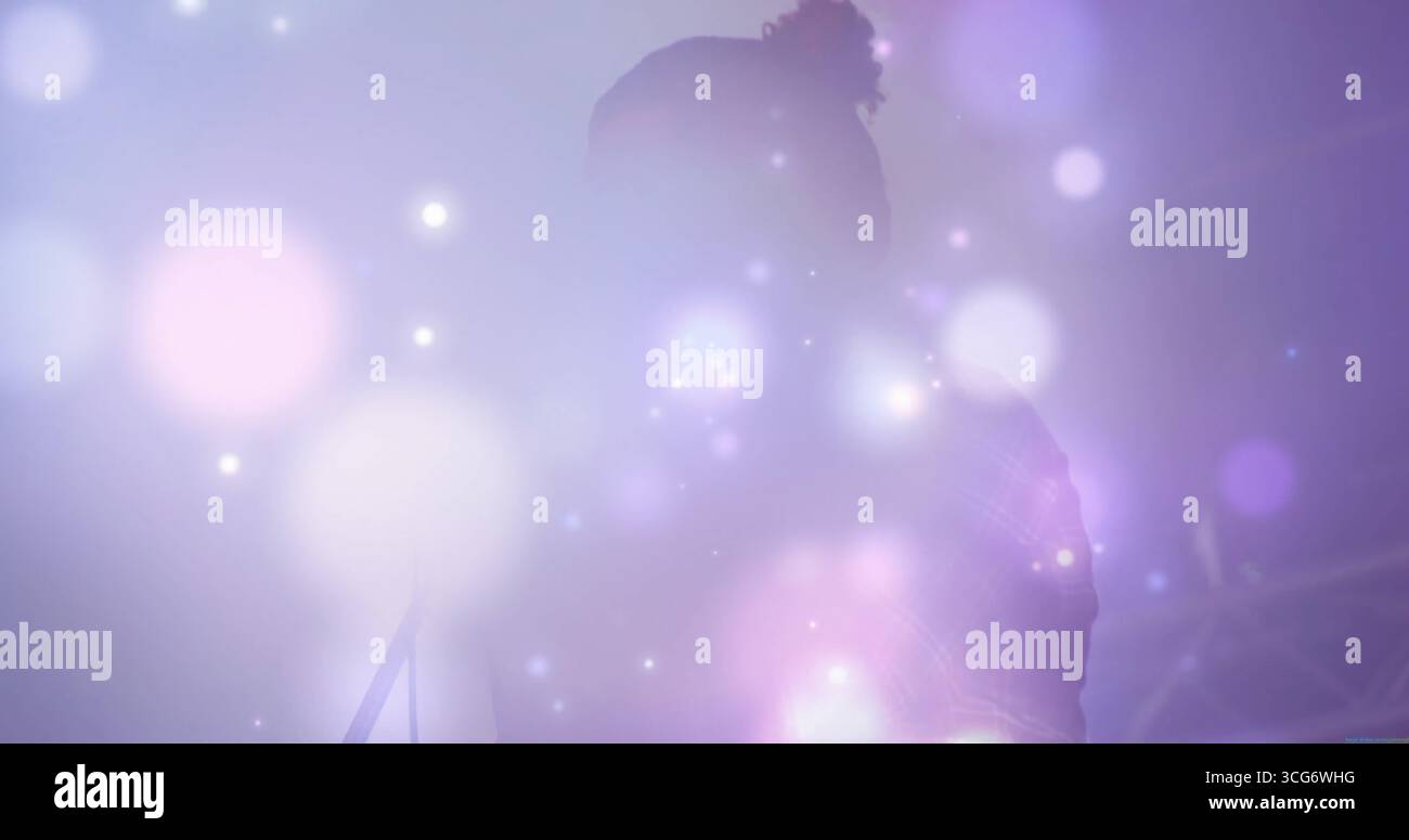 Männlicher Sänger in Jackett-Gesang auf der Konzertbühne, mit Dunst, Mikrofonständer, Traverse und Lichtern Stockfoto