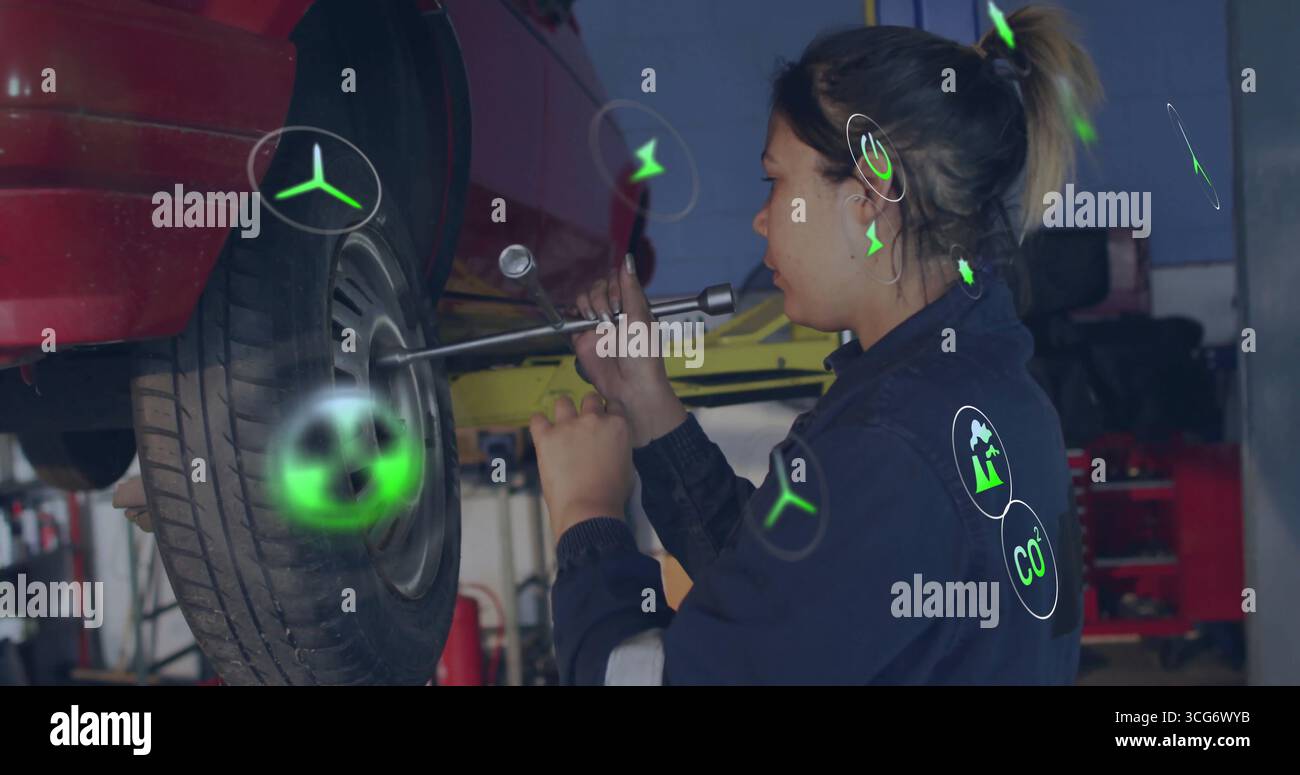 Mechanikerinnen in blauem Overall lösen Radmuttern mit Radschlüssel in Garage, Kopierraum Stockfoto