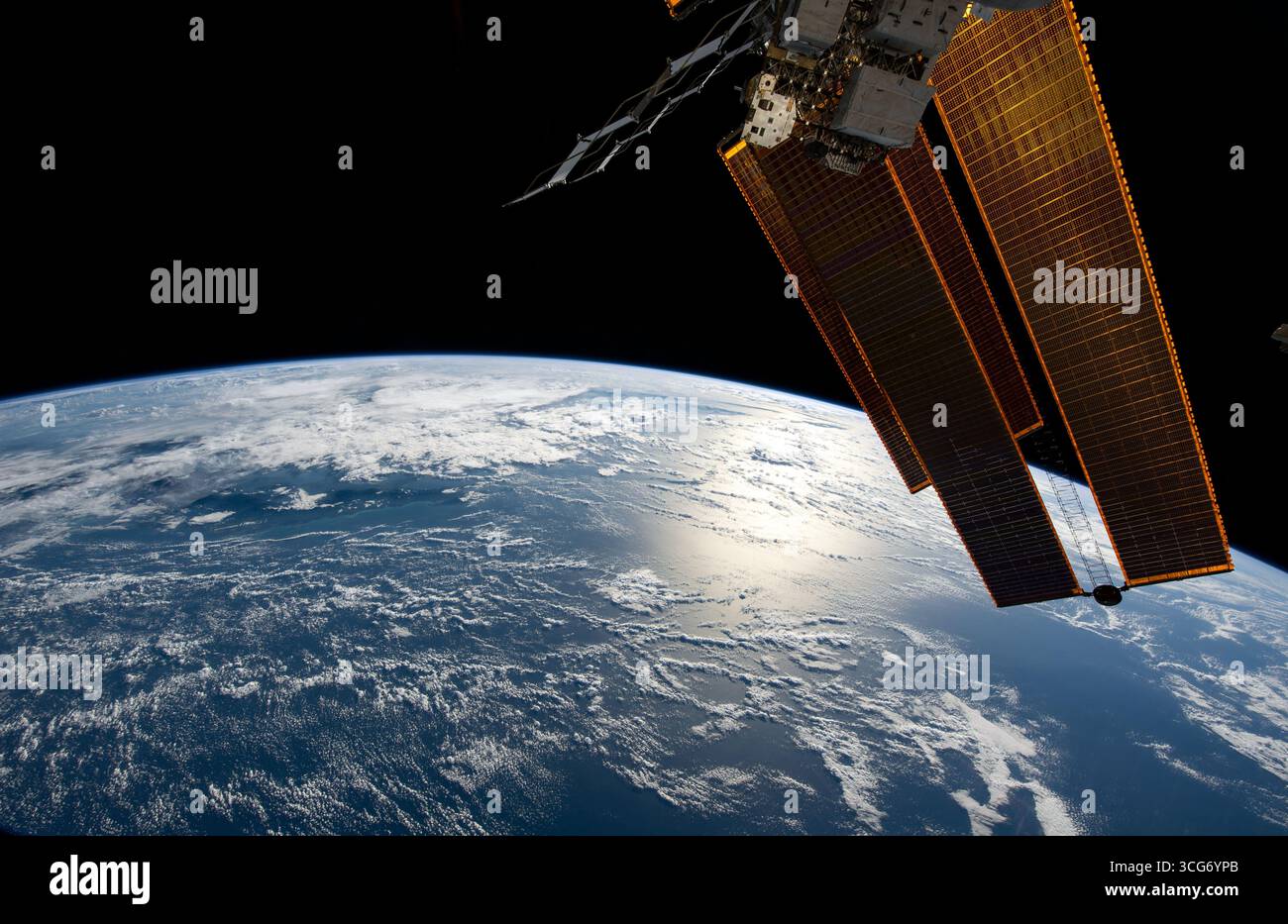 Der Sonnenschein strahlt vor der Korallensee nordöstlich von Australien, als die Internationale Raumstation 264 Meilen über dem Meeresspiegel umkreiste. Rechts im Vordergrund sind ein Paar der wichtigsten Solaranlagen der Station und ein Heizkörper abgebildet. Eine optimierte Version eines Originalbildes der ISS: NASA/ESA. Nur Redaktionelle Verwendung. Stockfoto