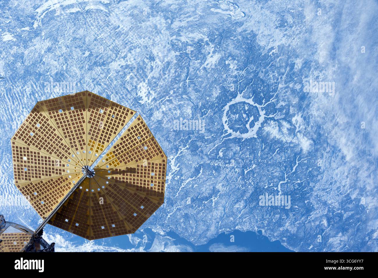 Der über 214 Millionen Jahre alte Manicouagan-Krater in Quebec, Kanada, ist ein leicht zu erkennendes Ziel für Astronauten, die Erdlandschaften 261 Meilen unterhalb der Raumstation fotografieren. Ein UltraFex-Solararray, eine von zwei Cymbal-förmigen Solararrays auf dem Northrop Grumman Cygnus Raumfrachter, ist im Vordergrund abgebildet, eine optimierte Version eines Originalbildes der NASA: NASA/DPettit Stockfoto