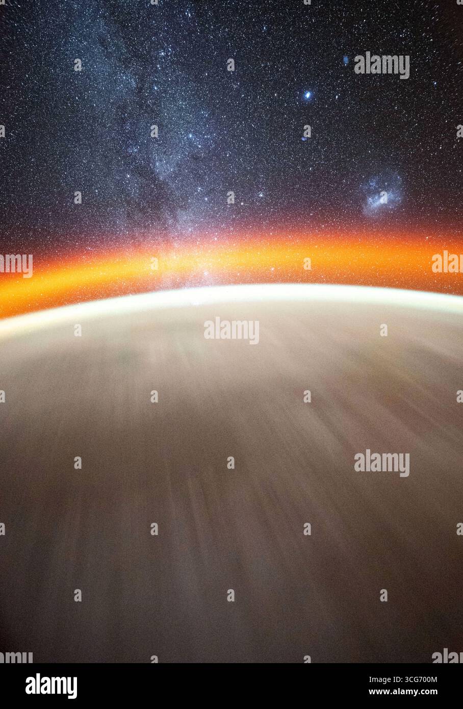 Dieses Himmelsbild, das vom NASA-Astronauten Don Pettit aufgenommen wurde, verwendet eine Kamera mit schlechten Lichtverhältnissen und Langzeiteinstellungen und zeigt die Milchstraße jenseits des Horizonts der Erde, gekrönt von einem atmosphärischen Leuchten. Die große und die kleine Magellansche Wolke sind auch als die Internationale Raumstation über dem Pazifischen Ozean zu unterscheiden. Eine optimierte, neu ausgerichtete und zugeschnittene Version eines Originalbildes der NASA: NASA/DPettit. Stockfoto