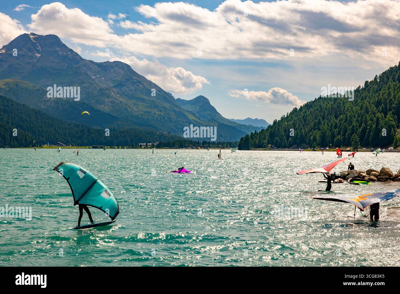 Wingsurfen auf dem Alpensee Silvaplana an einem sonnigen Sommertag mit Bergblick in Silvaplana, Maloja, Graubünden, Schweiz. Stockfoto