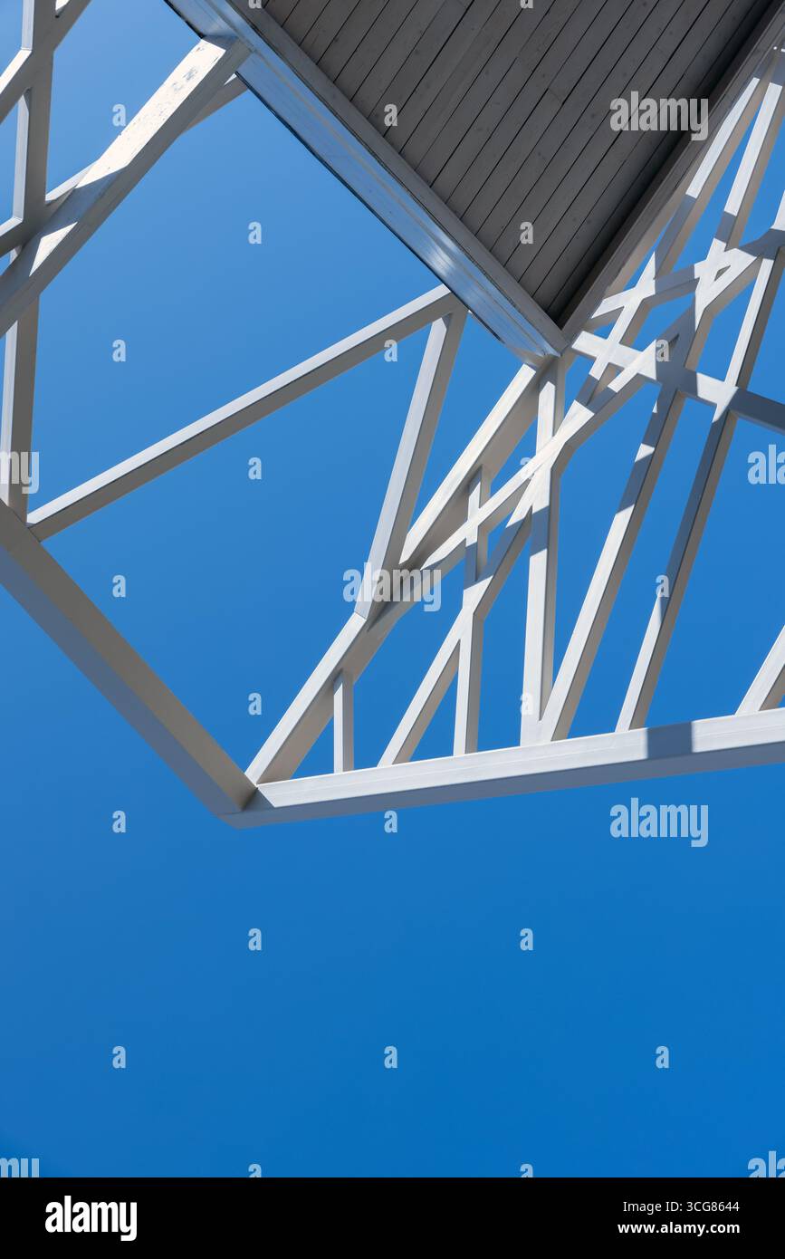 Modernes architektonisches Detail eines weißen Stahlrahmens vor einem hellblauen Himmel, das Minimalismus und Strukturdesign betont Stockfoto