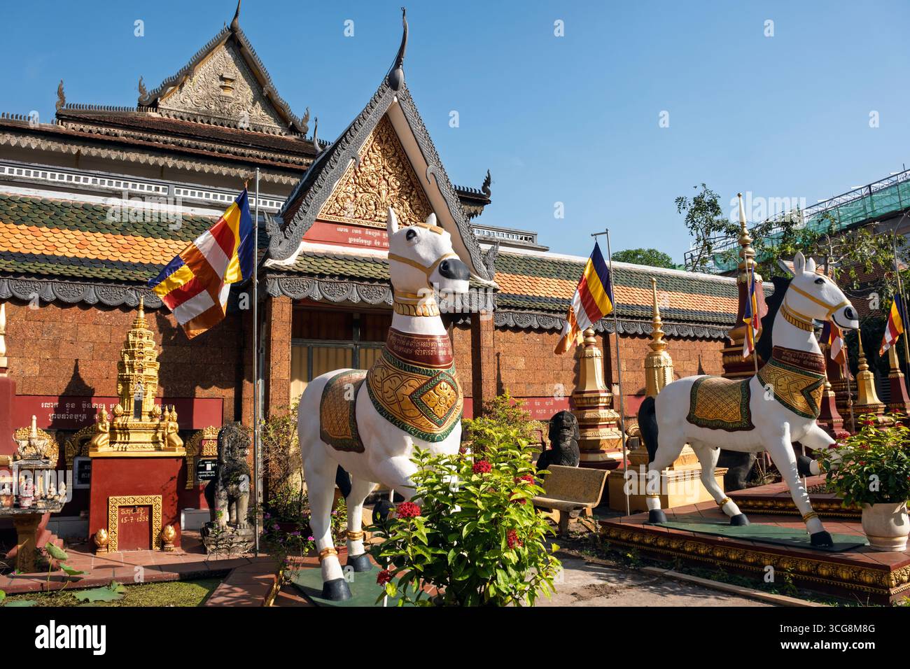 Ein Paar weißer Pferde, dargestellt in einer der vielen farbenfrohen Skulpturen im buddhistischen Tempelkomplex Wat Preah Prom Rath, Siem Reap, Kambodscha Stockfoto