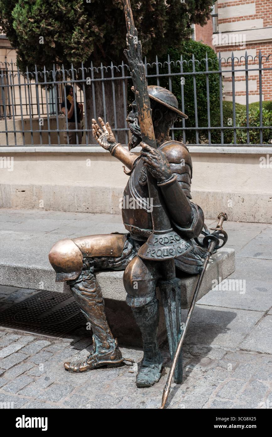 Blick auf die Statue von Don Quijote, die nachdenklich auf einer Bank sitzt, seine Rüstung strahlte unter der warmen Sonne, eine Figur der literarischen Geschichte, die in Bronze verewigt wurde, Al Stockfoto