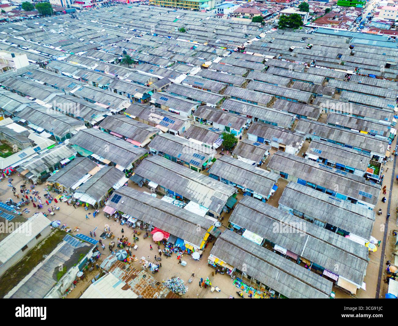 Aus der Vogelperspektive dicht gepackte Marktstände schaffen einen strukturierten Wandteppich aus Handel und Gemeinschaft unter dem riesigen Himmel, Tudun Wada, Kaduna, Nigeria. Stockfoto