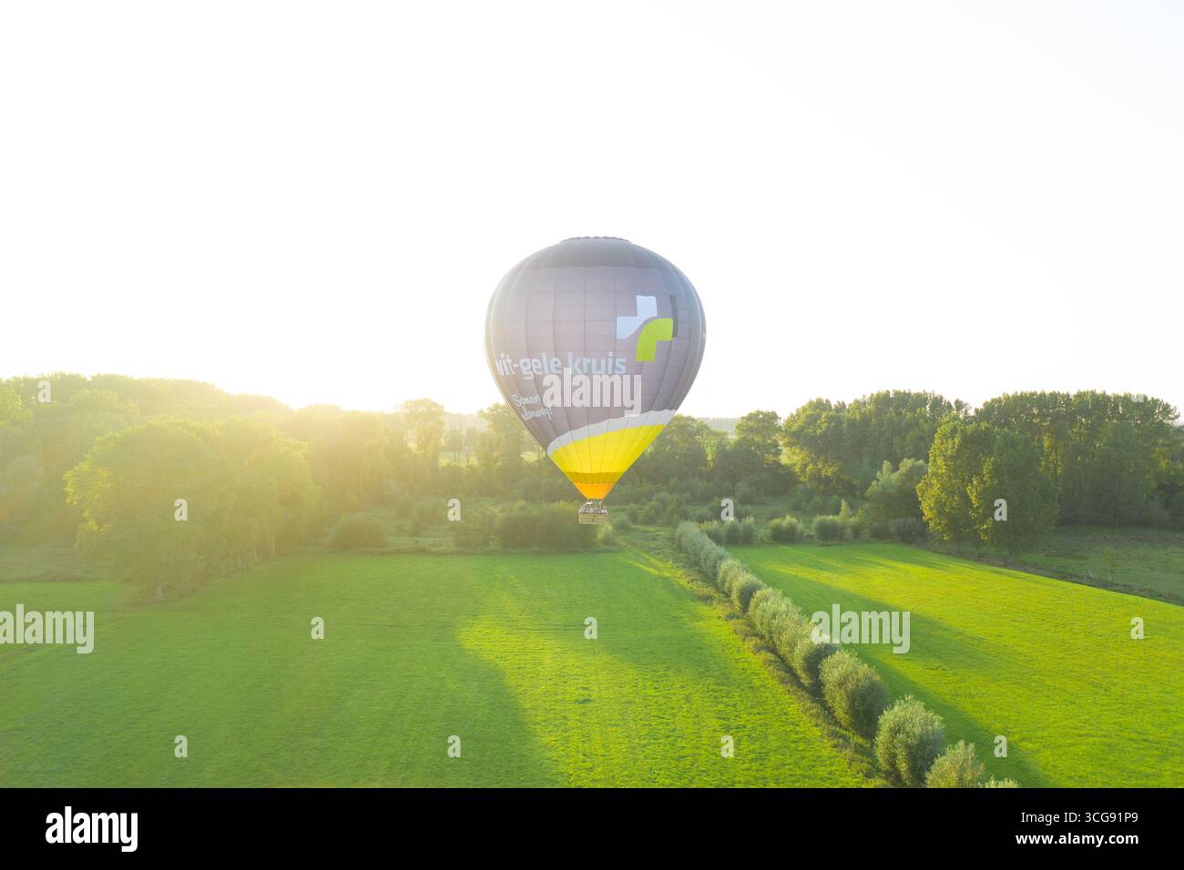 Sint-Martens-Latem, Belgien - 09. September 2023: Aus der Vogelperspektive eines mit „le-Goele louis“ bemalten Heißluftballons schweben anmutig über die üppige Landschaft Stockfoto