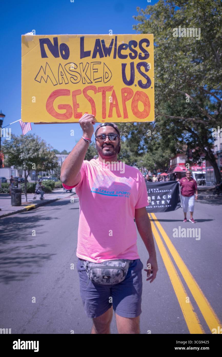 Bei der African American Day Parade in Nyack NY hält ein Mann ein handgemachtes Schild gegen die gesetzlose Maskierte Gestapo hoch, vermutlich EIS. Stockfoto
