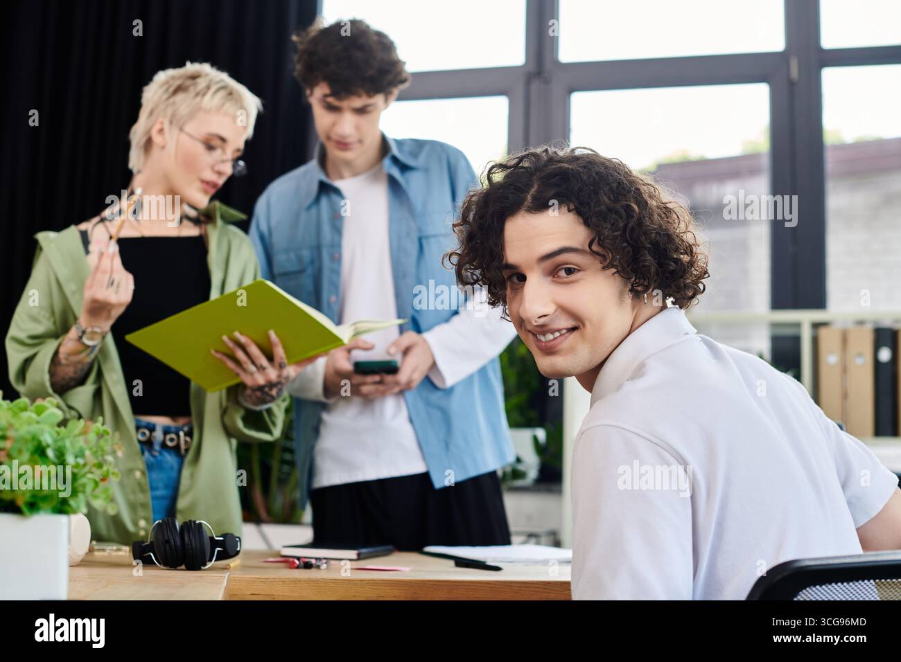 Drei junge Menschen beteiligen sich an Diskussionen und Teamarbeit und fördern ein dynamisches Arbeitsumfeld. Stockfoto