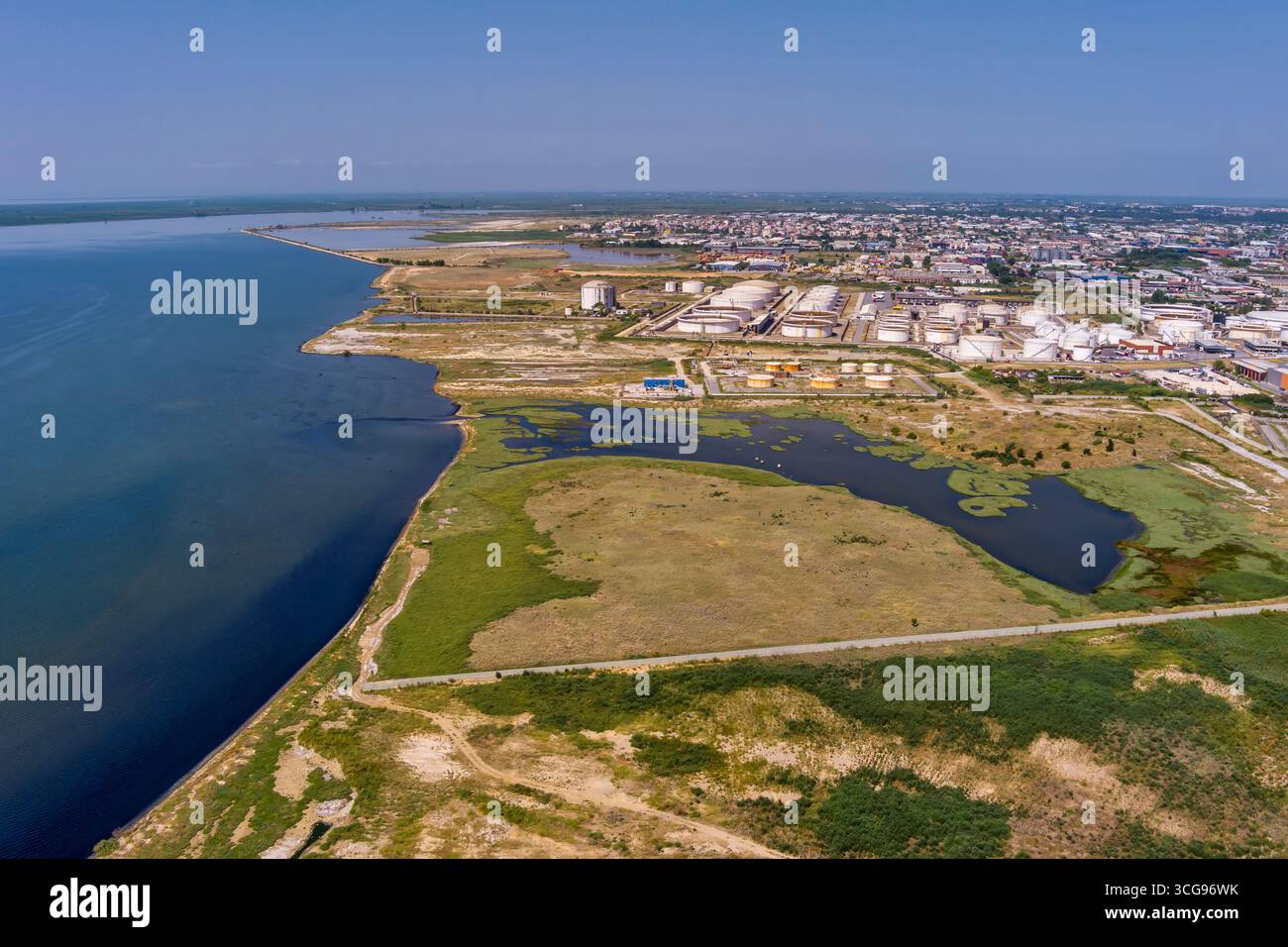 Blick aus der Vogelperspektive auf die Westküste von Thessaloniki mit Industrietanks, Zersiedelung und dem Thermaischen Golf, der Wirtschaft und Küstenlandschaft verbindet. Stockfoto
