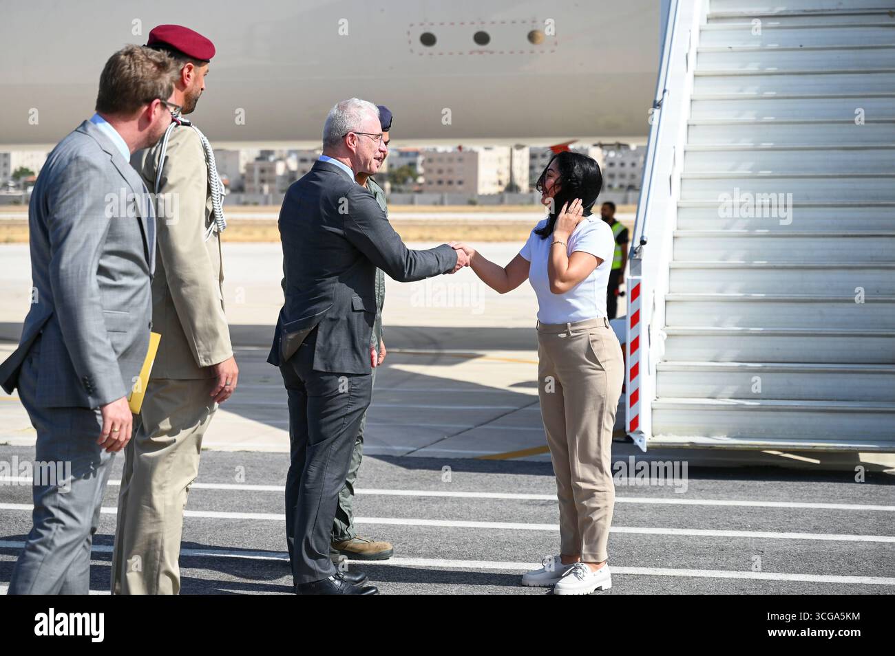 Amman, Jordanien. August 2025. Reem Alabali Radovan (SPD, r), Bundesminister für wirtschaftliche Zusammenarbeit und Entwicklung, wird am Flughafen von Guido Kemmerling, Gesandter der deutschen Botschaft in Jordanien, begrüßt. Der Minister reist mit einer Delegation von Politikern und Journalisten nach Israel, Jordanien, Saudi-Arabien und in die palästinensischen Gebiete. Quelle: Katharina Kausche/dpa/Alamy Live News Stockfoto
