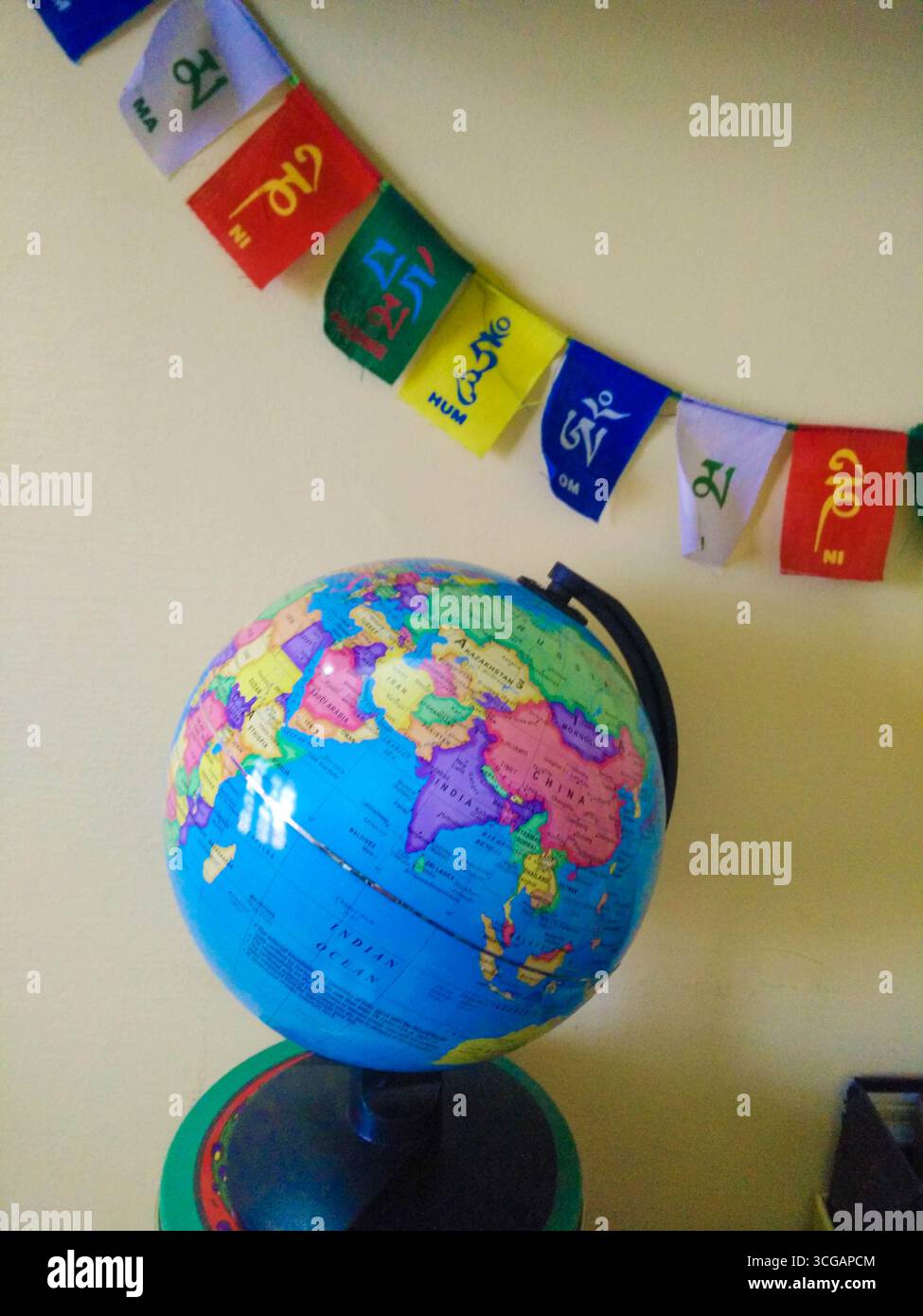 Eine Weltkugel, begleitet von einer buddhistischen Flagge, die globalen Frieden, Spiritualität, kulturelle Einheit und die Verbreitung buddhistischer Lehren in der symbolisiert Stockfoto