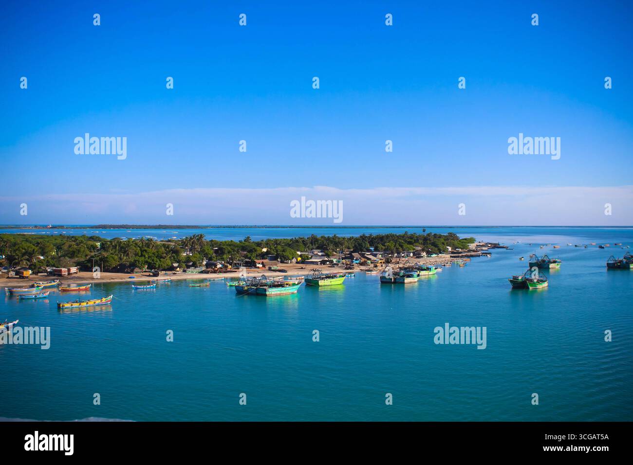 Auf dem Weg nach Dhanuschkodi führt eine enge Straße, die vom Meer flankiert wird, zu den eindringlichen Ruinen der Geisterstadt, die einen atemberaubenden Blick auf das Meer und die Geschichte bietet. Stockfoto