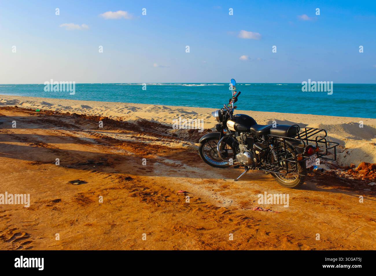 Auf dem Weg nach Dhanuschkodi führt eine enge Straße, die vom Meer flankiert wird, zu den eindringlichen Ruinen der Geisterstadt, die einen atemberaubenden Blick auf das Meer und die Geschichte bietet. Stockfoto
