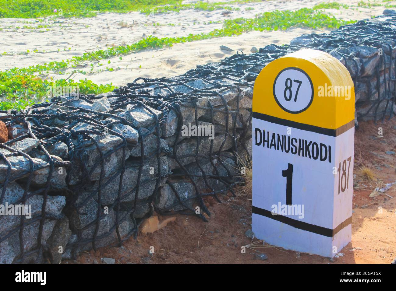 Auf dem Weg nach Dhanuschkodi führt eine enge Straße, die vom Meer flankiert wird, zu den eindringlichen Ruinen der Geisterstadt, die einen atemberaubenden Blick auf das Meer und die Geschichte bietet. Stockfoto