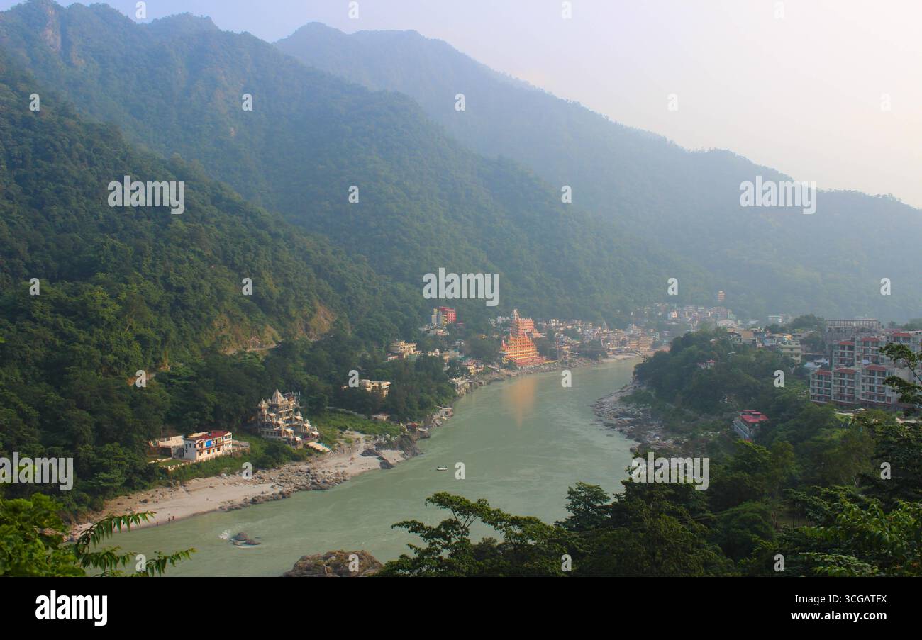 Malerische Aussicht auf die Stadt Rishikesh in Indien. Das spirituelle Herz von Yoga und Meditation liegt am heiligen Ganges Fluss, umgeben vom ruhigen Himalaya. Stockfoto