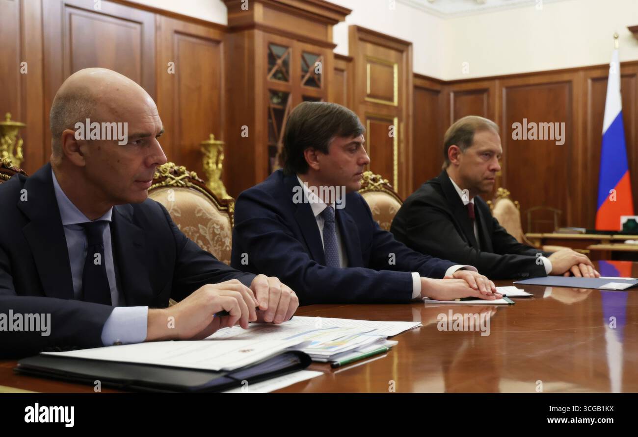 Moskau, Russland. August 2025. Der russische Finanzminister Anton Siluanov, links, der Bildungsminister Sergei Kravtsov, Zentrum, und der erste stellvertretende Premierminister Denis Manturow, rechts, hören während eines Treffens mit Mitgliedern der russischen Regierung unter dem Vorsitz von Präsident Wladimir Putin im Kreml am 27. August 2025 in Moskau zu. Quelle: Vyacheslav Prokofyev/Kreml Pool/Alamy Live News Stockfoto