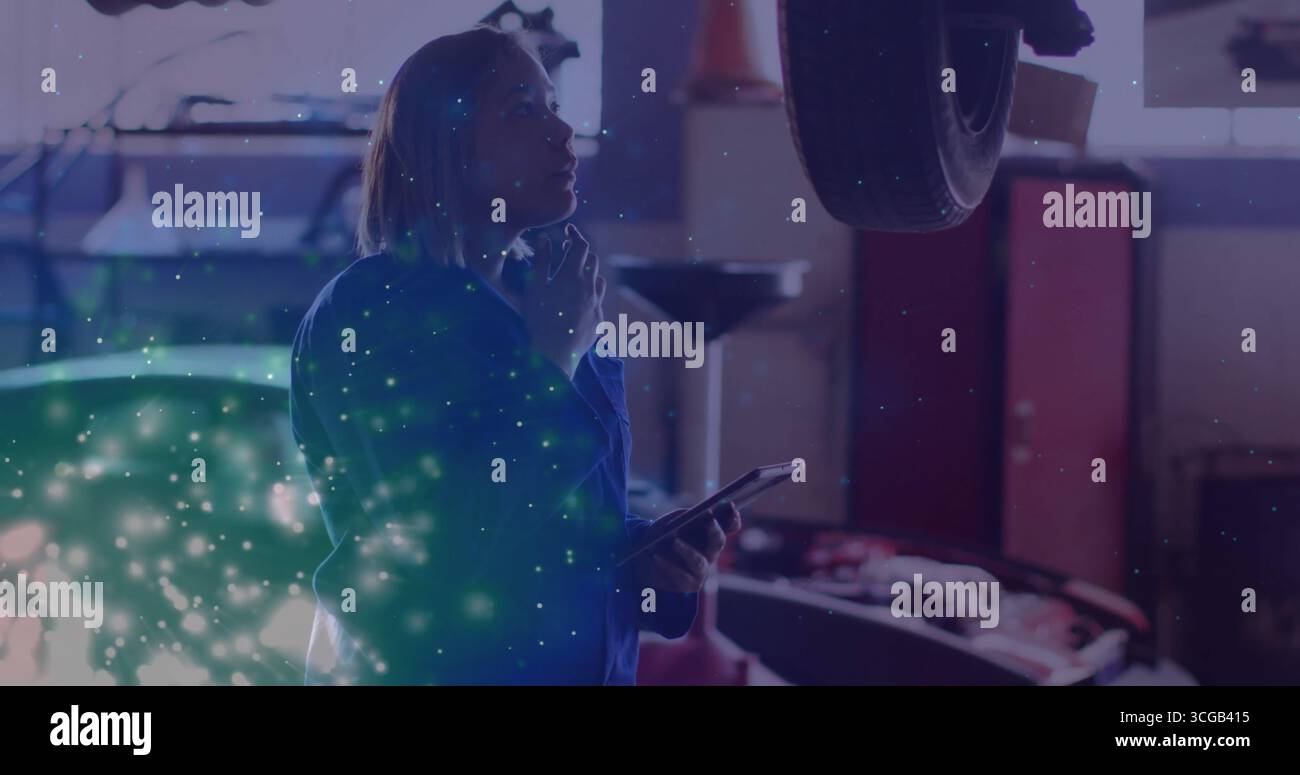 Inspektion des Technikers in Overalls Fehlerbehebung bei hängenden Autorrädern in der Autogarage mit Tablet Stockfoto