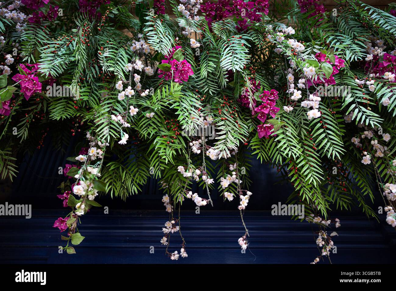 Plastikblumenkranz an einer blauen Holzwand Stockfoto