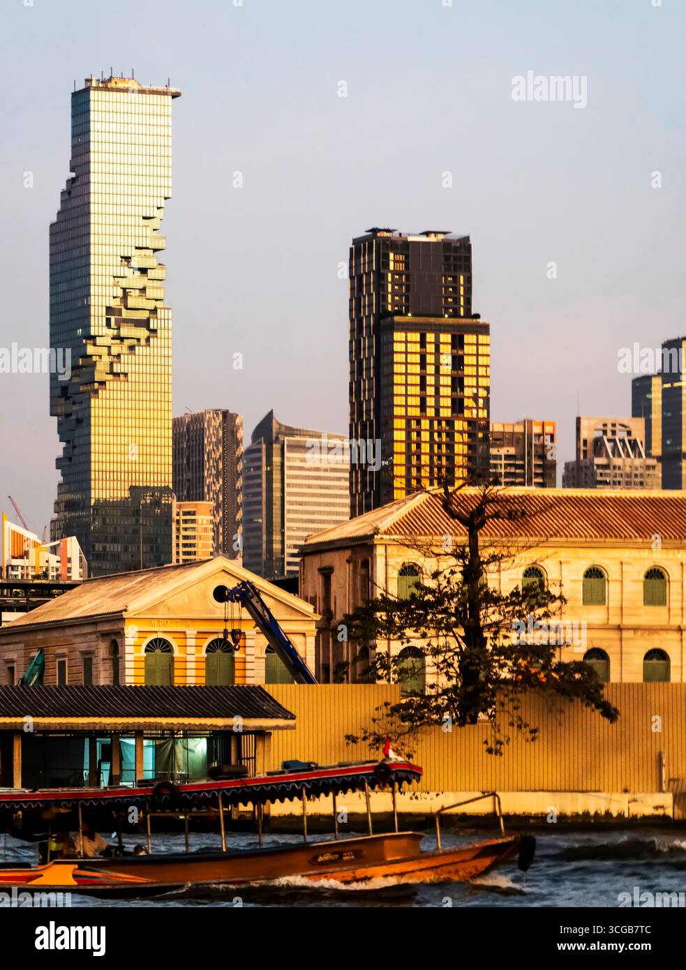Eine Skyline der Stadt mit modernen Wolkenkratzern und einem historischen Gebäude entlang eines Flusses, mit einem Boot im Vordergrund Stockfoto
