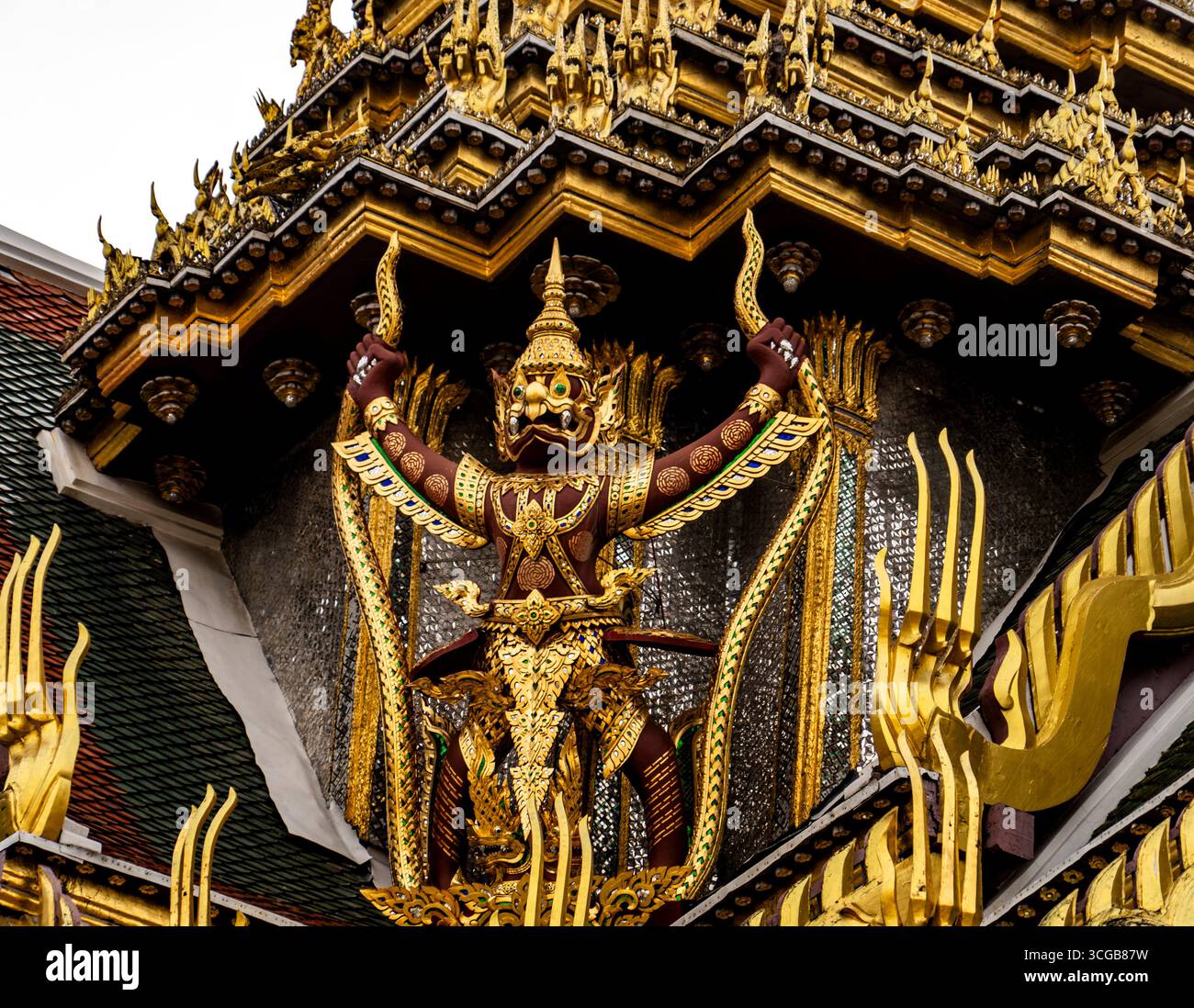 Verzierte goldene Statue einer mythischen Figur in einem Tempel, komplizierte Details, lebendige Farben, traditionelle Architektur Stockfoto