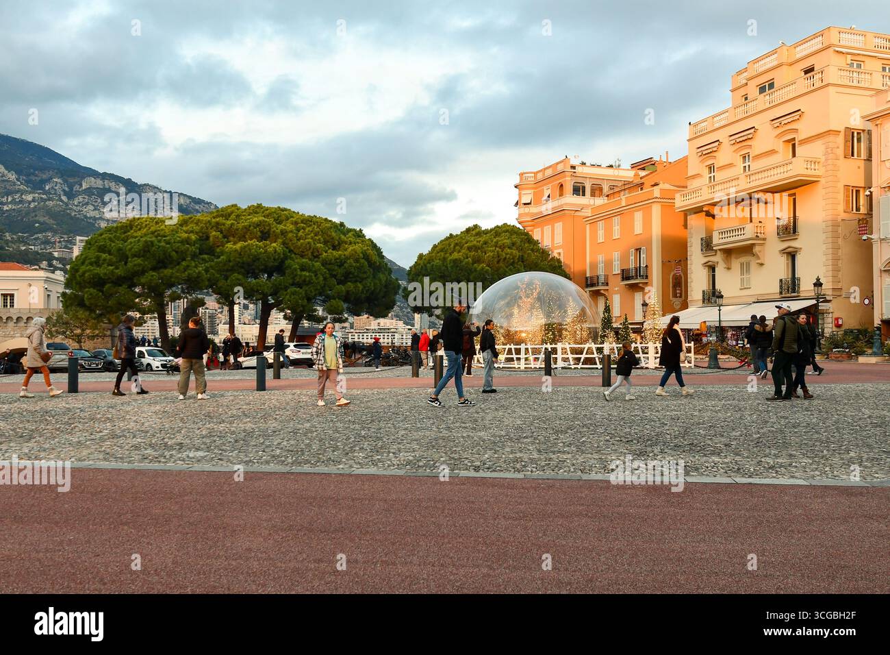 Blick auf den Place du Palais (Palastplatz) mit Weihnachtsdekoration und Wanderungen durch Touristen, im Winter bei Sonnenuntergang, Monaco Ville, Fürstentum Monaco Stockfoto
