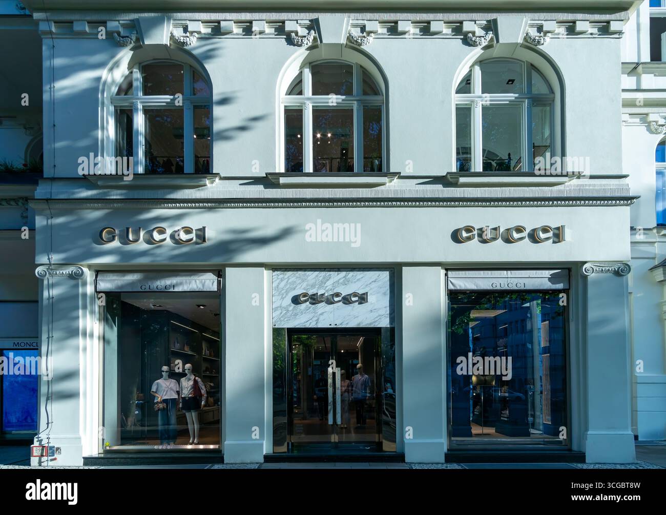 Die elegante Gucci-Ladenfassade am Berliner Kurfürstendamm mit klassischen Bogenfenstern und minimalistischem Markeneingang. Stockfoto