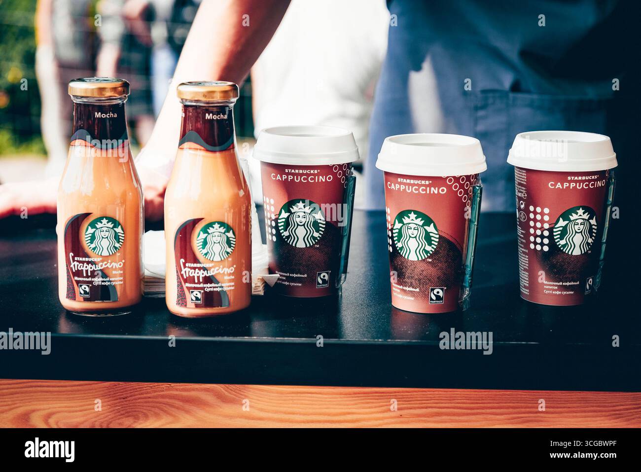 Sankt Petersburg, Russland, 27. Juli 2019, Plastikflaschenbecher mit Starbucks Kaffeeständer auf dem Tisch Stockfoto