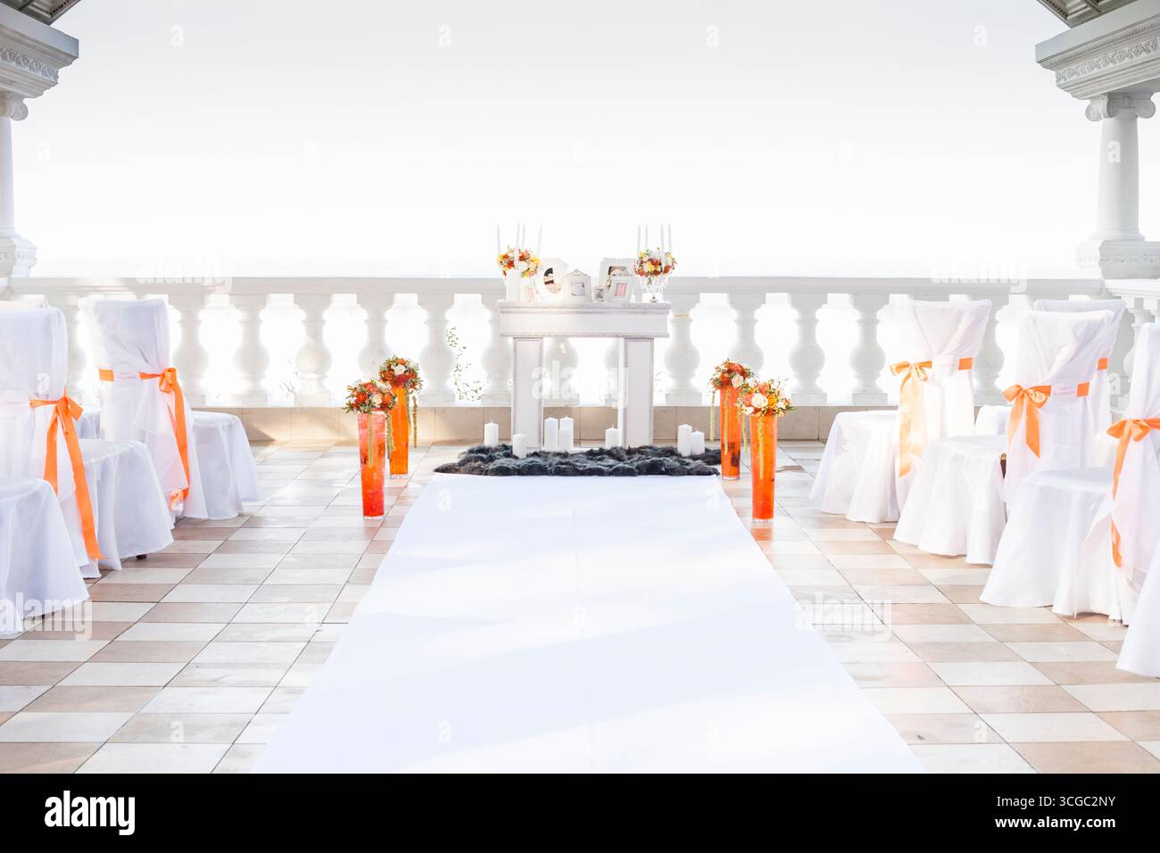 khabarowsk, russland, 20.10.2013 Hochzeitszeremonie im Freien mit weißen Stühlen, orangefarbenen Bändern, Blumenarrangements und einem Gang-Läufer auf einem Balkon. Stockfoto