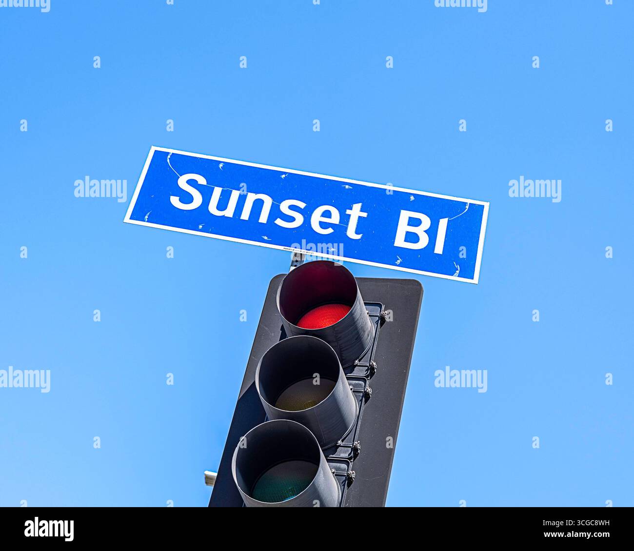 Nahaufnahme eines Sunset Blvd-Schilds vor einem blauen Himmel in Los Angeles, CA. Stockfoto
