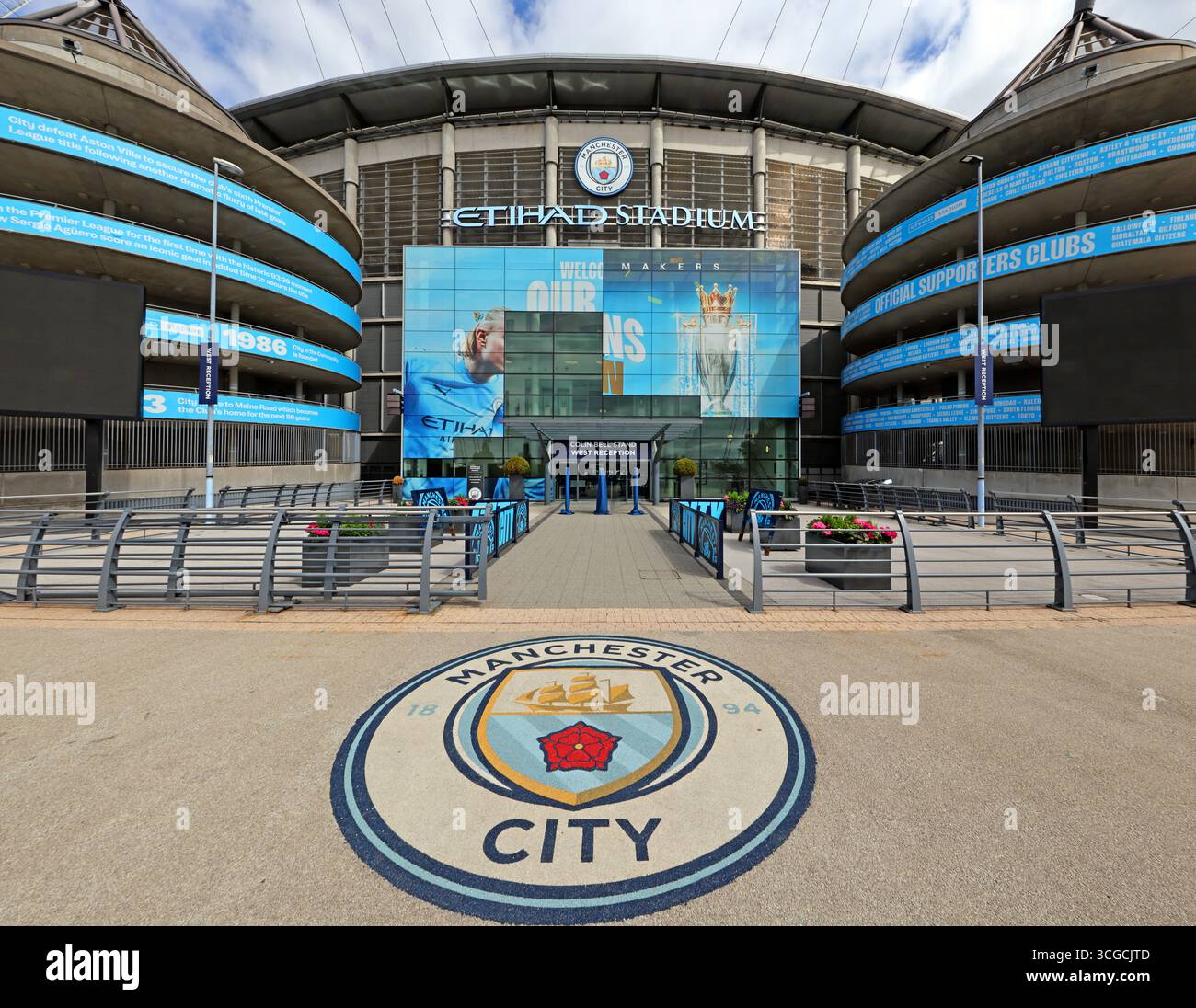 Weitwinkelansicht des Haupteingangs zum Etihad Stadium, Heimstadion des MCFC, im Osten von Manchester, England, Großbritannien. Das Manchester City Wappen ist deutlich sichtbar Stockfoto