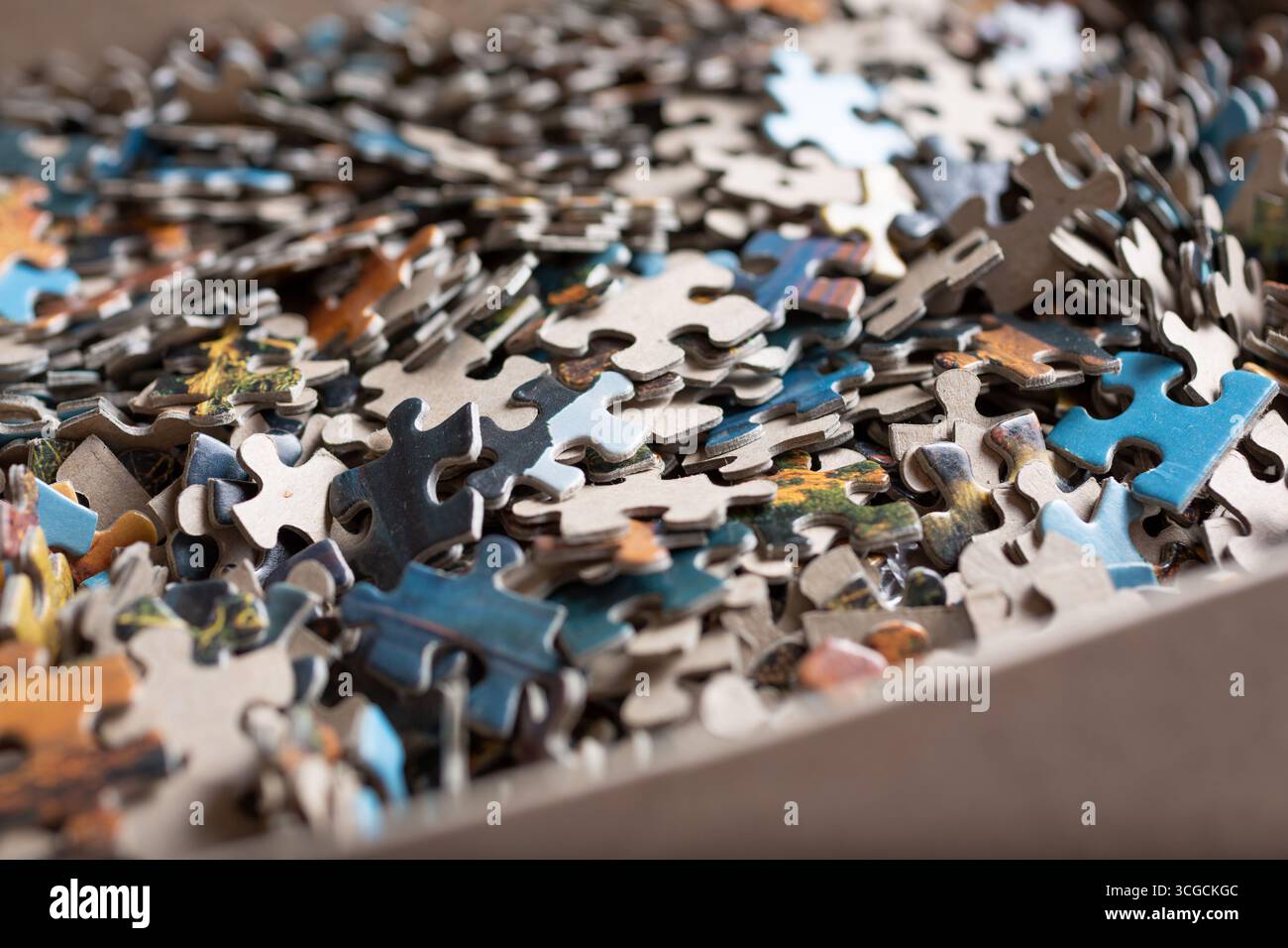 Eine Nahansicht einer Puzzlebox und ihrer vielen Teile. Stockfoto
