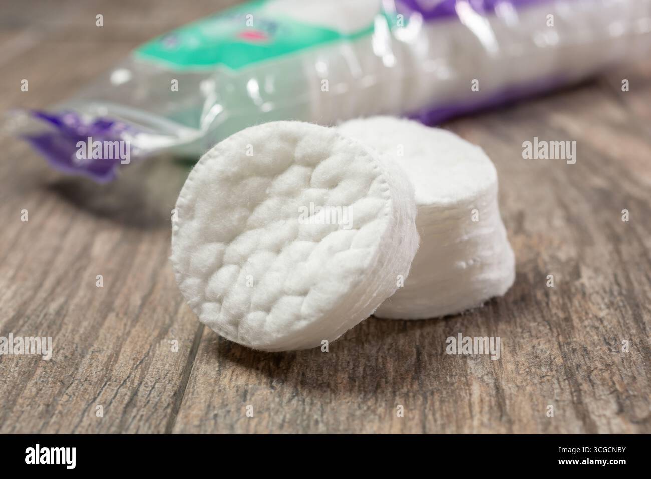 Eine Nahaufnahme eines Stapels runder Make-up-Baumwollpads auf einer Holzoberfläche. Stockfoto
