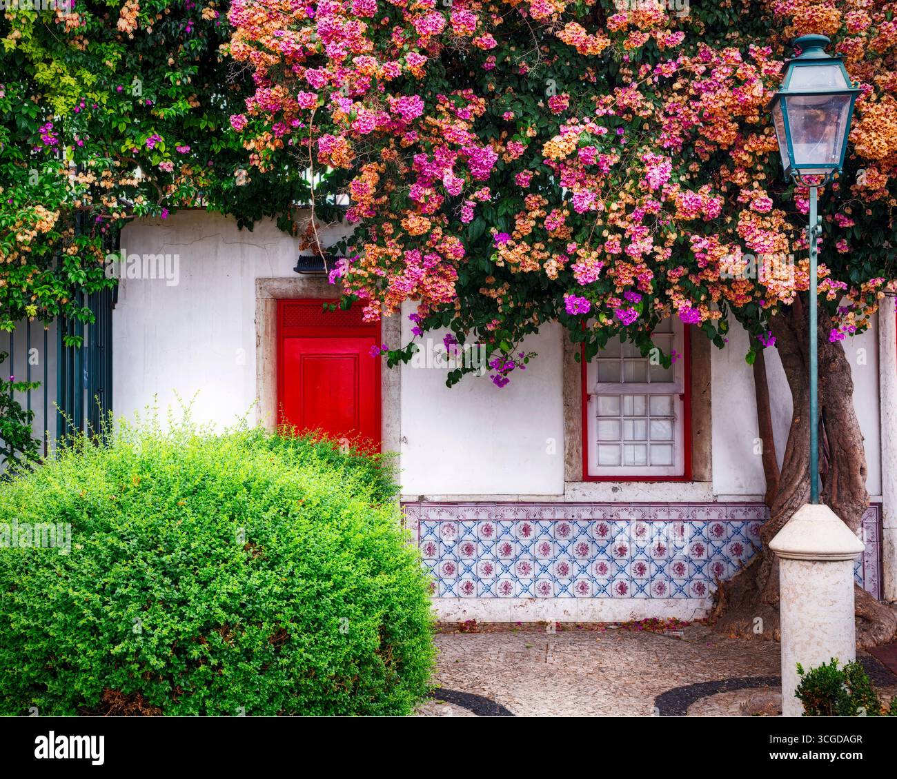 Kleines Ferienhaus in der Altstadt von Lissabon mit traditionellen Azulejos und blühenden Blumen, Portugal Stockfoto