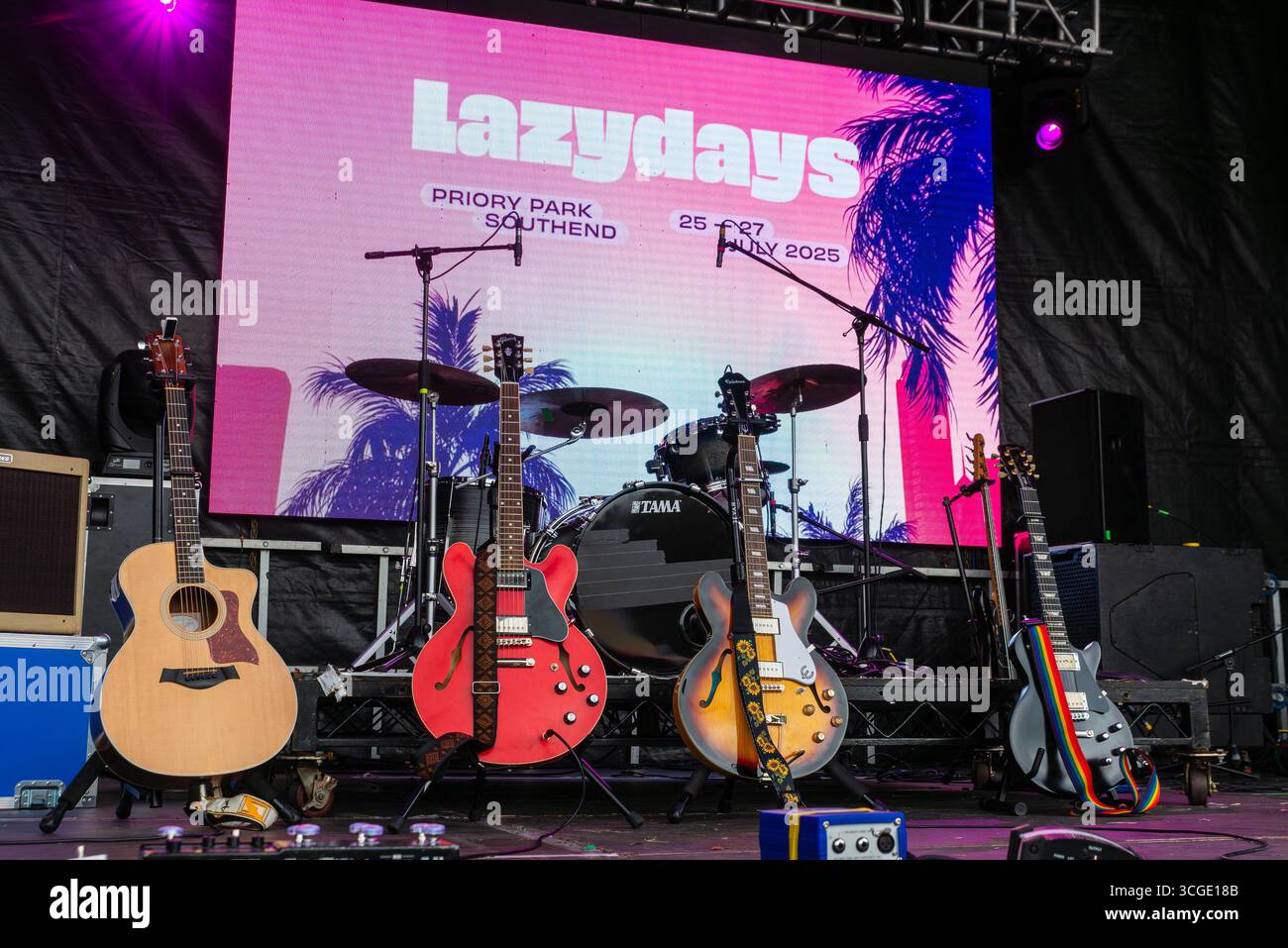 Gitarren auf der Bühne des Lazydays Musikfestivals in Priory Park, Southend on Sea, Essex, Großbritannien. Verschiedene elektrische und akustische Gitarren stehen zur Auswahl Stockfoto
