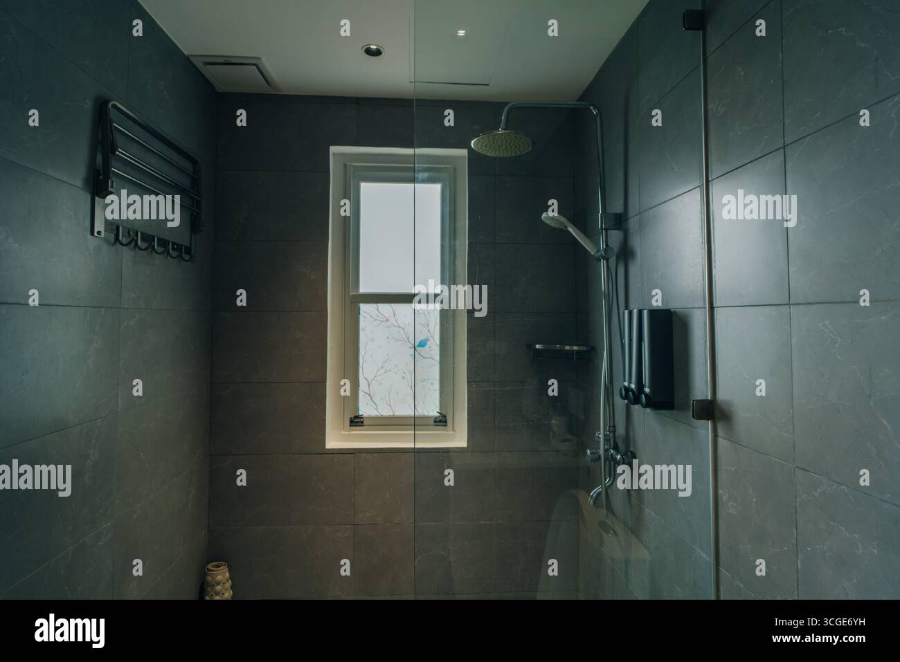 Bad in modernem Stil mit grauen gefliesten Wänden. Es gibt eine Dusche mit einer Glaswand. Hochwertige Fotos Stockfoto