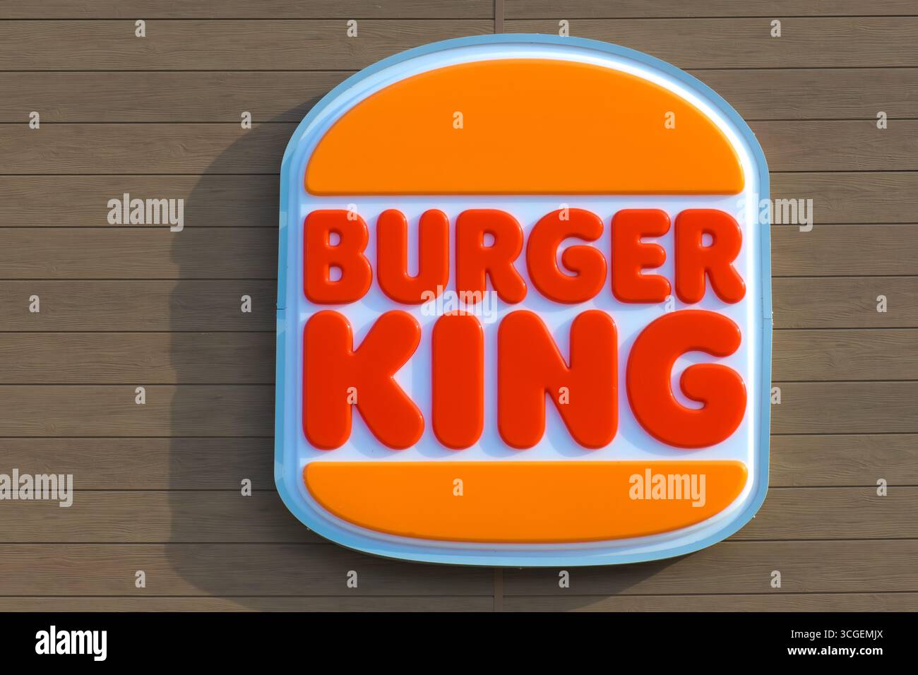 Leuchtend rotes und orangefarbenes Burger King-Logo-Schild an einer Holzwand. Stockfoto