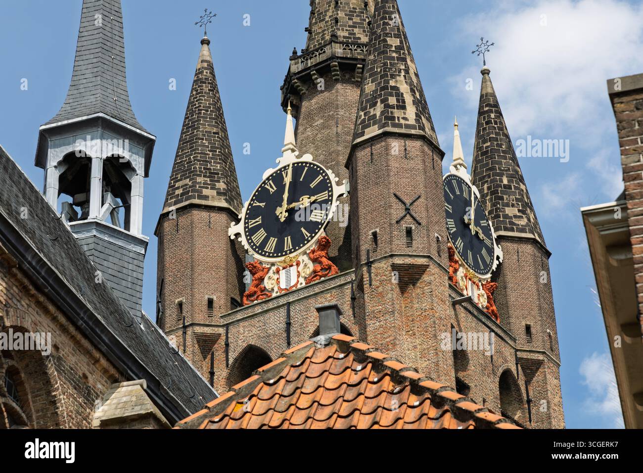 Nahaufnahme der berühmten Oude Kerk (alte Kirche) in Delft, Niederlande, mit ihrem historischen Uhrenturm und ihrer beeindruckenden gotischen Architektur. Stockfoto