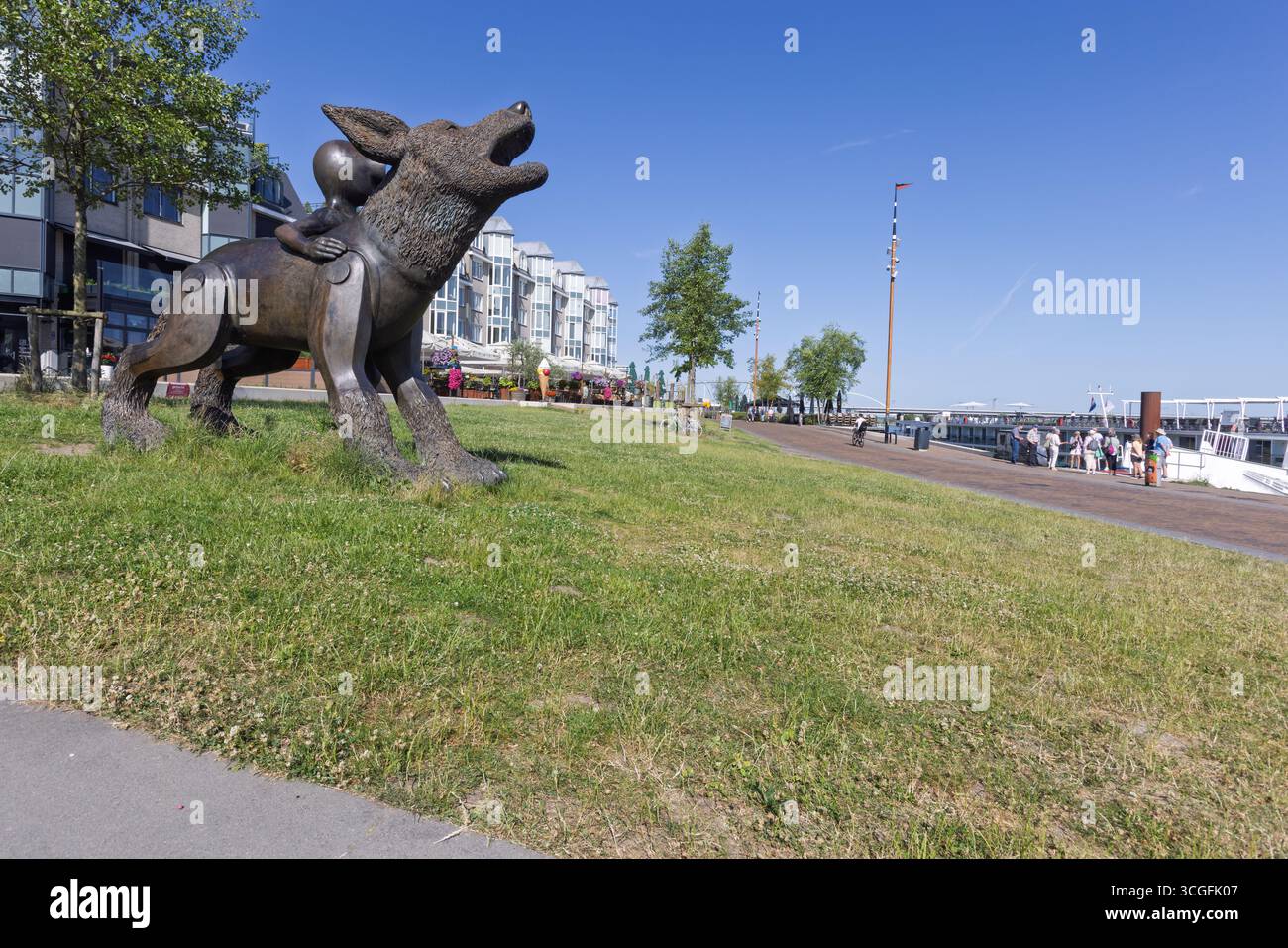 Die Statue „Kind met de Wolf“ auf der Waalkade, eine Bronzeskulptur eines Jungen auf einem Wolf, überblickt den Fluss Waal in Nijmegen. Stockfoto