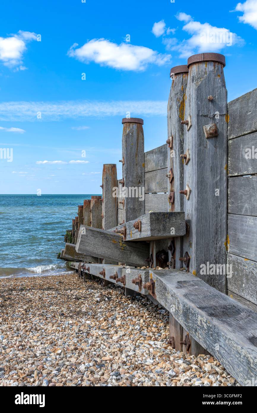 Alte hölzerne Leisten (oder Buhnen), die den Kieselstrand vor Erosion schützen. Erschossen in der Küstenstadt Whitstable an der Nordküste von Kent. Stockfoto