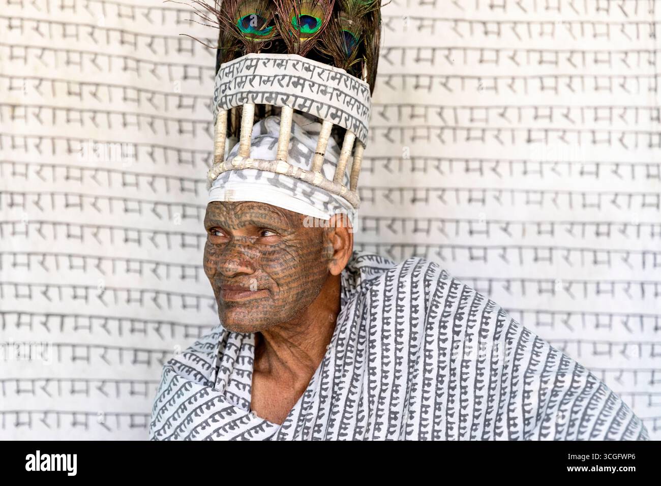 Mitglied der Ramnani Samaj Schule mit dem Hindugott namens Lord Rama, auf sein Gesicht tätowiert, Schal und Hut aus Pfauenfedern, Shivrinarayan, Indien Stockfoto